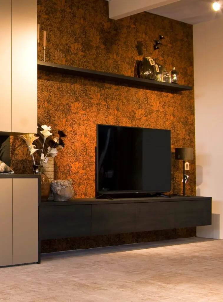 Donker zwevend tv-meubel met wandplank voor een oranje bloemenbehang