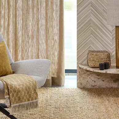 Linnen gordijnen, jute vloerkleed en fauteuil in de showroom Nieuw-Vennep