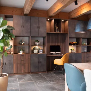 Wandvullende kastenwand met bureau en verlichte nissen in de showroom Nieuw-Vennep