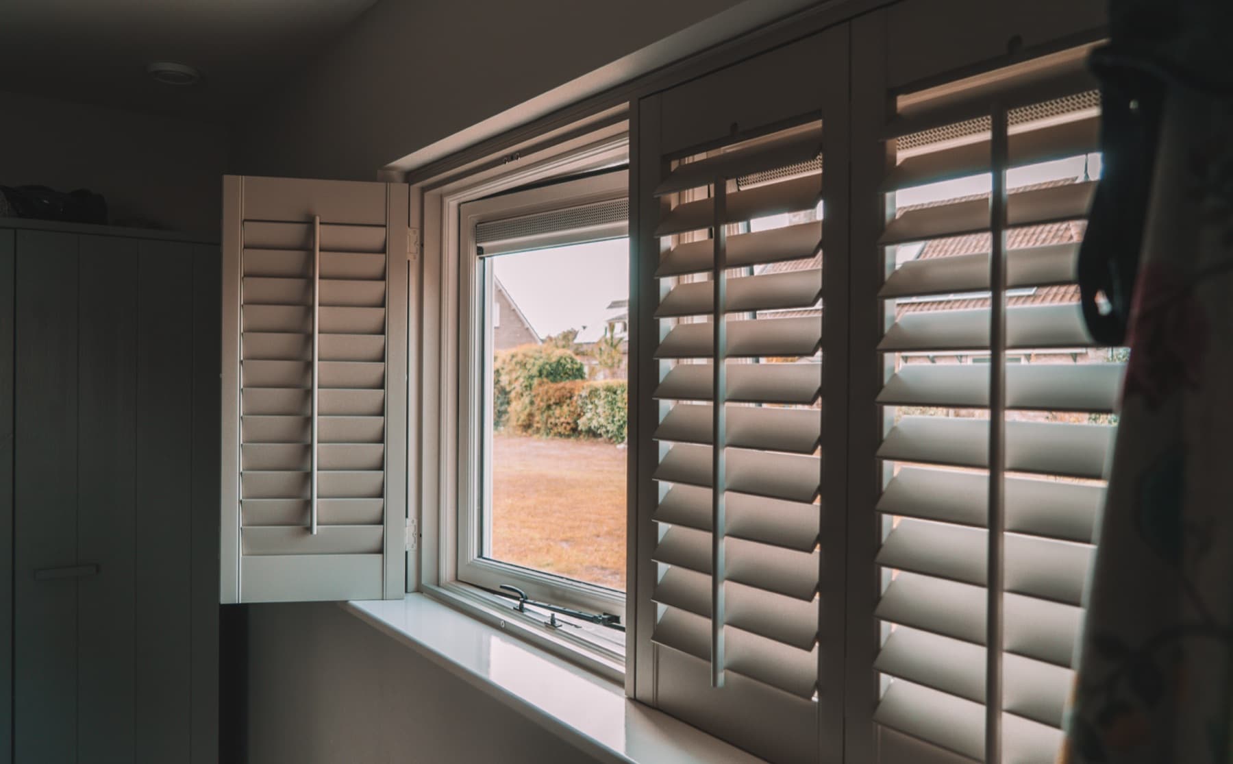 Shutter zijaanzicht met open klepraam en uitzicht op de tuin