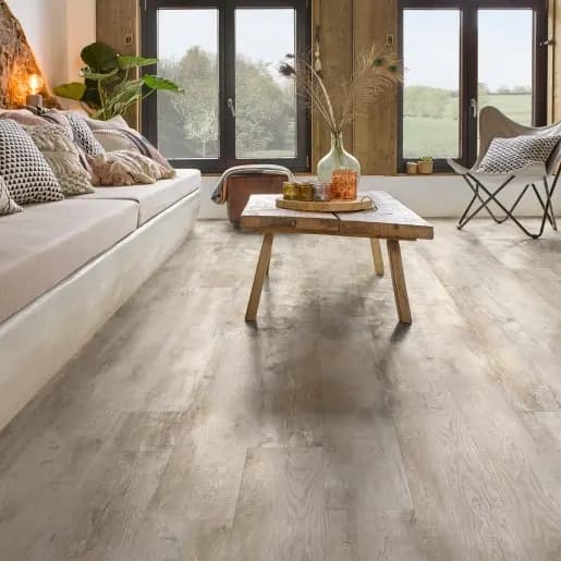Laminaat in verweerde eikenlook in een lichte zithoek met houten salontafel