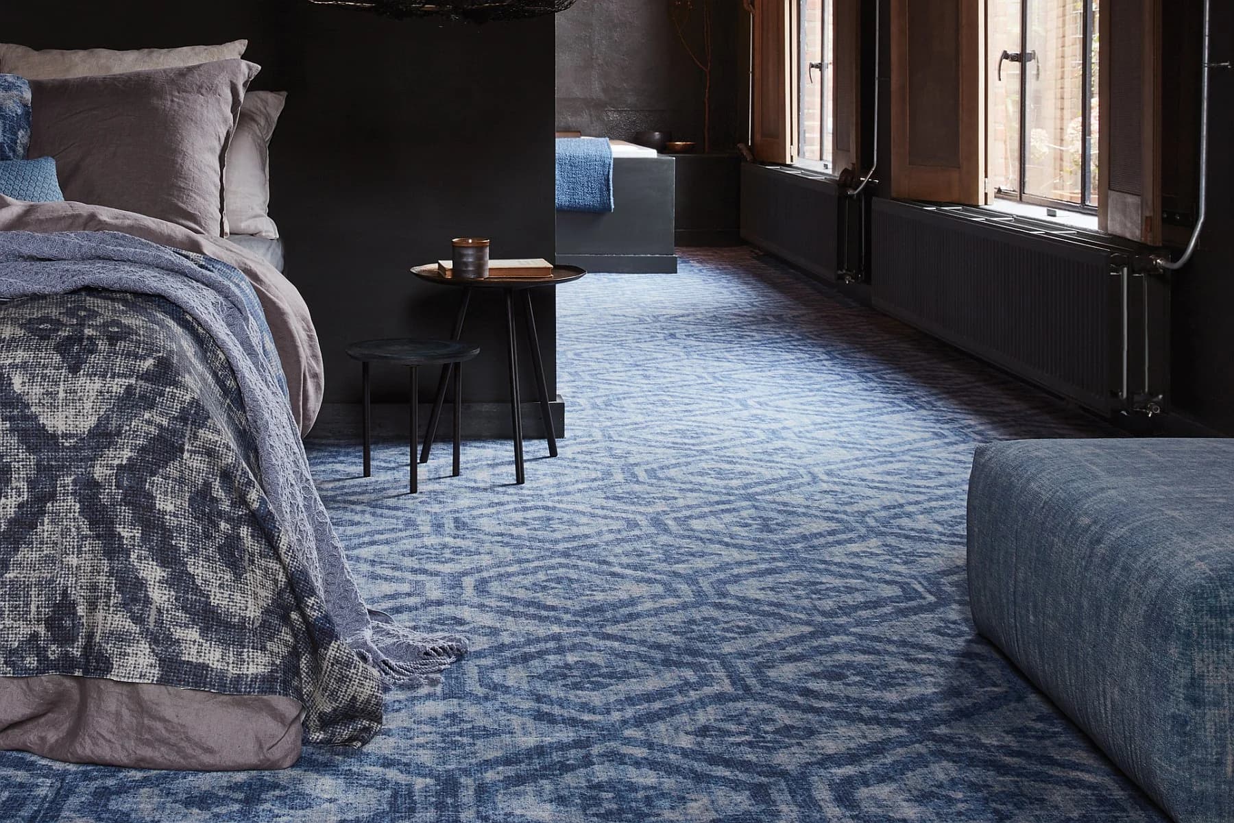 Blauw tapijt met grafisch patroon in een donkere slaapkamer